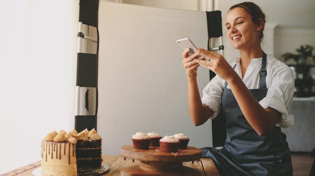Baker taking a photo of her home-made cupcakes