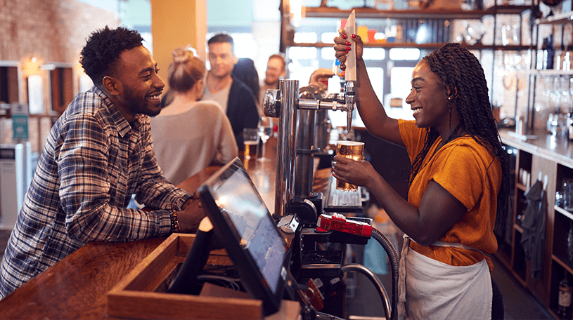 Bar owner pouring a beer for a customer