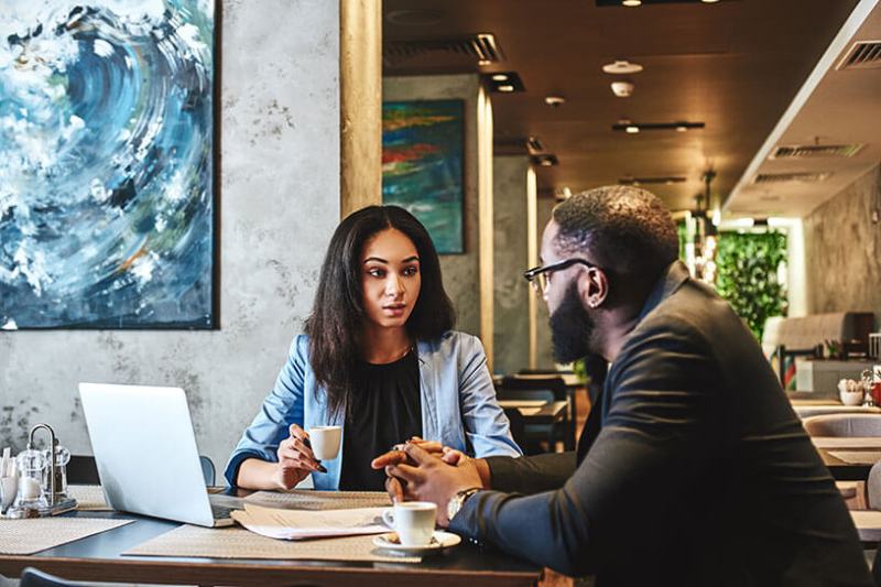 Manager giving feedback to an employee in a coffee shop