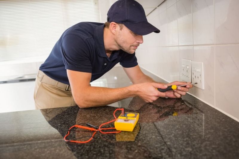 An electrician testing a rental property for an EICR report