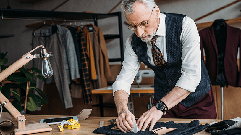 A tailor working with fabric at a studio