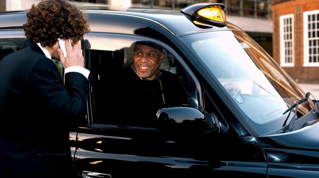 Taxi driver speaking to passenger
