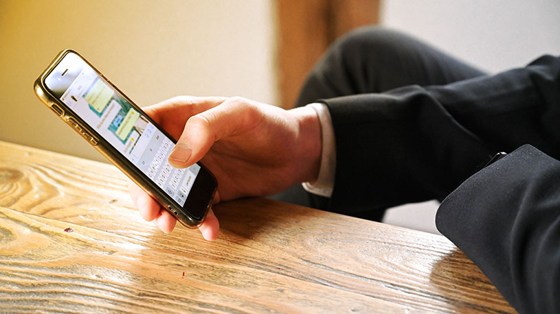 A business owner using WhatsApp on his phone