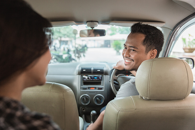 A self-employed Uber driver talks with his customer in the car
