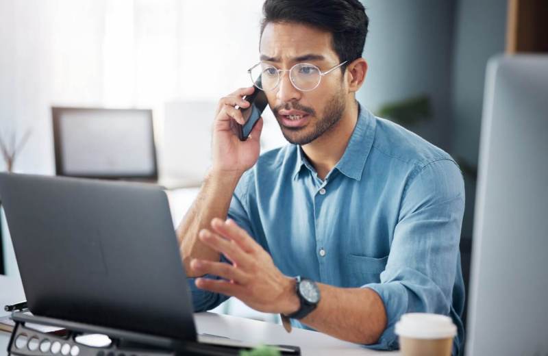 Phone call, entrepreneur and businessman planning company growth strategy on mobile conversation as communication. Laptop, cellphone and serious man startup founder in discussion and networking