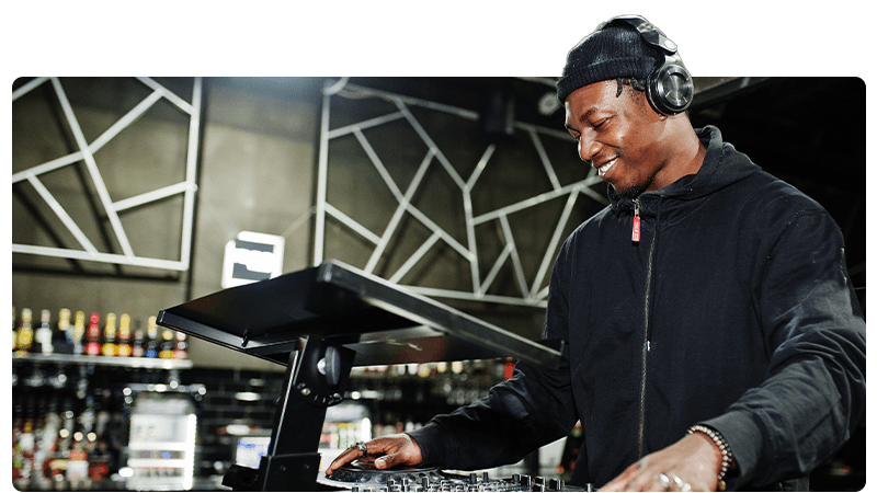 A DJ wearing a black jacket and headphones