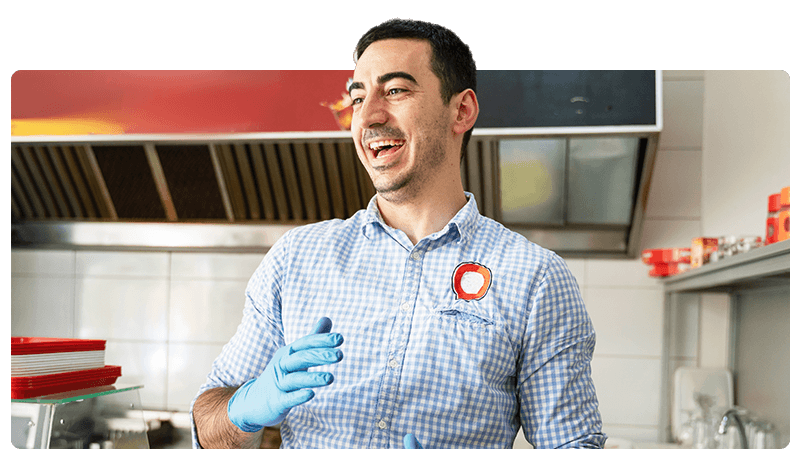 Fish and chip shop owner in a blue shirt and gloves