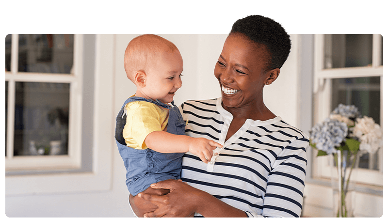A nanny holding a smiling baby