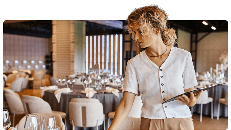 Event organiser with a clipboard setting tables