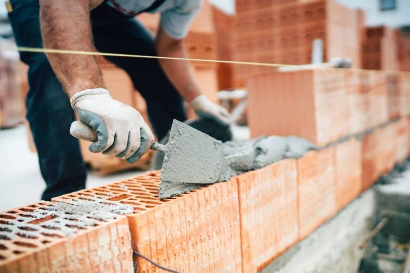 Close up of bricklayer building a wall