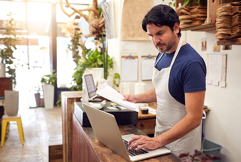 Shop owner using a laptop