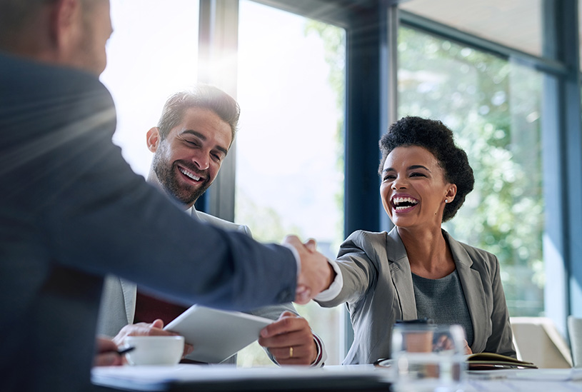 Two business owners shaking hands after completing a deal