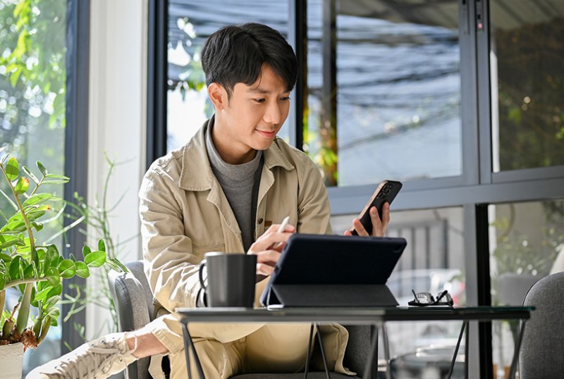 Business owner looking at tablet and phone