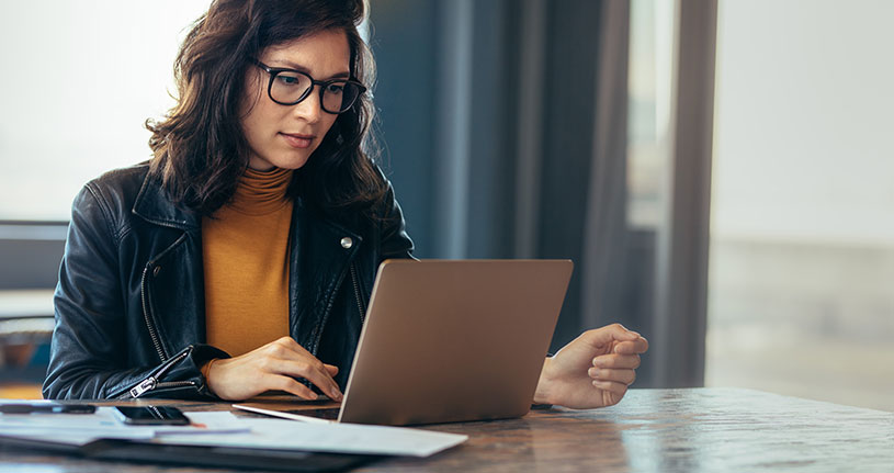 A female business owner submits a tax return on her laptop
