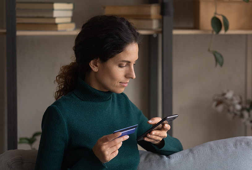 Business owner looking at phone and bank card