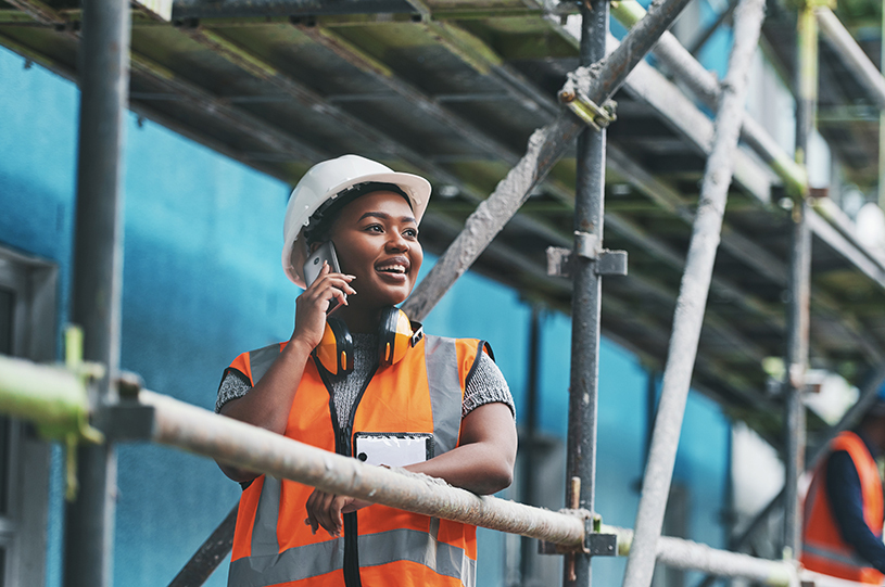 A female builder takes a phone call on a UK construction site