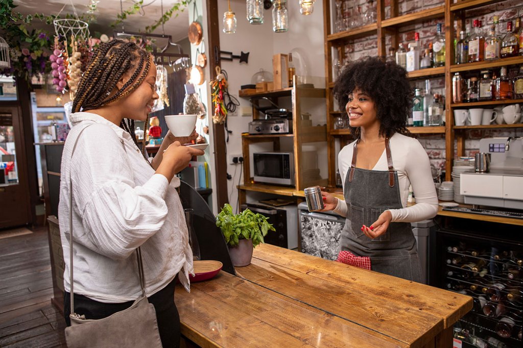 Coffee shop owner serving a customer in London