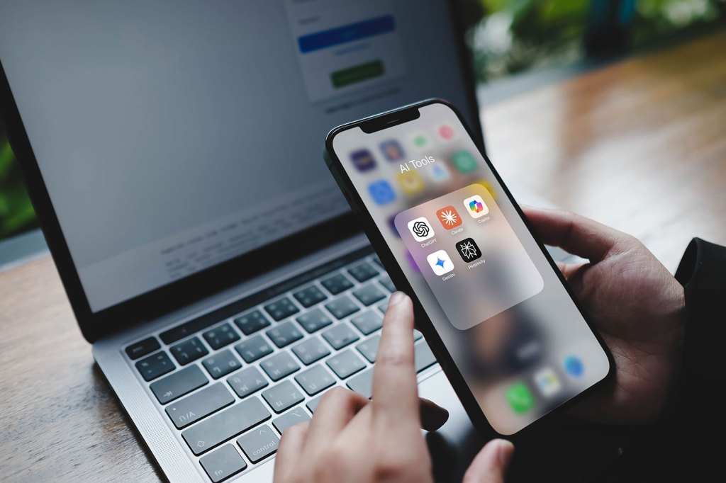 A person opening a folder on their mobile phone with popular AI tools including ChatGPT