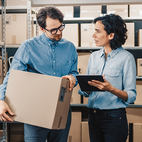 Two people in a warehouse with boxes