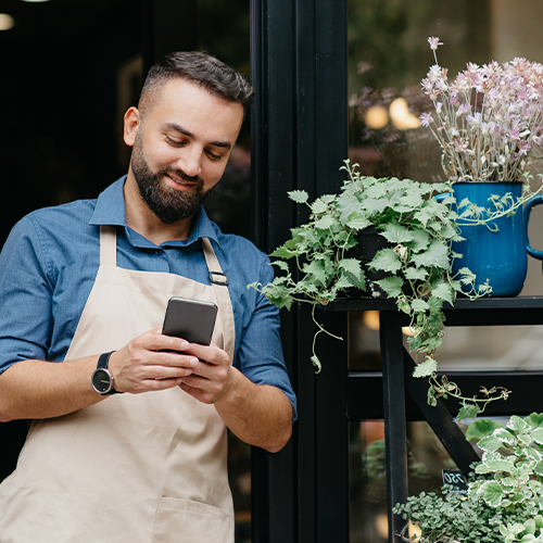 Man on his phone outside a plant shop