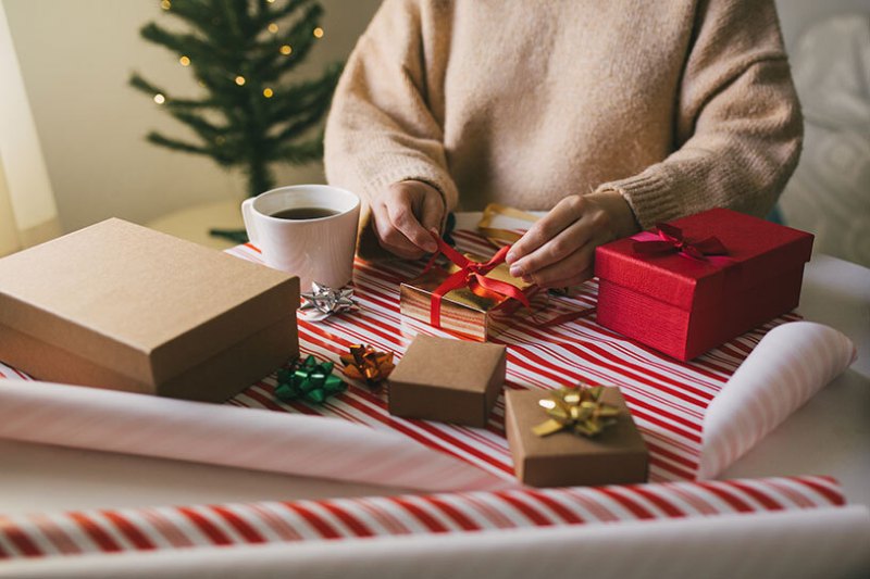 Woman in knitted jumper wrapping presents