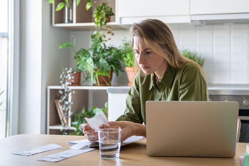 Woman with laptop and receipts chasing invoices