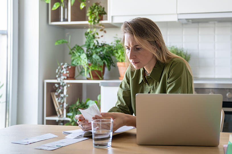 Woman with laptop and receipts chasing invoices