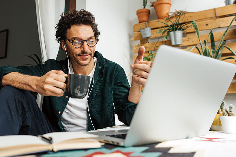 Freelancer contractor working from a laptop and drinking from a mug