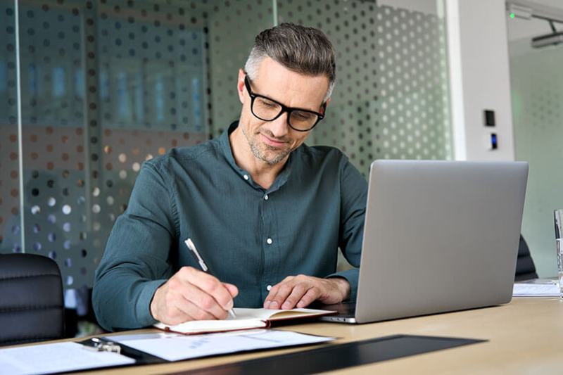 Man wearing glasses working on laptop