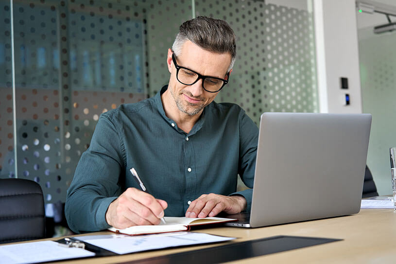 Man wearing glasses working on laptop